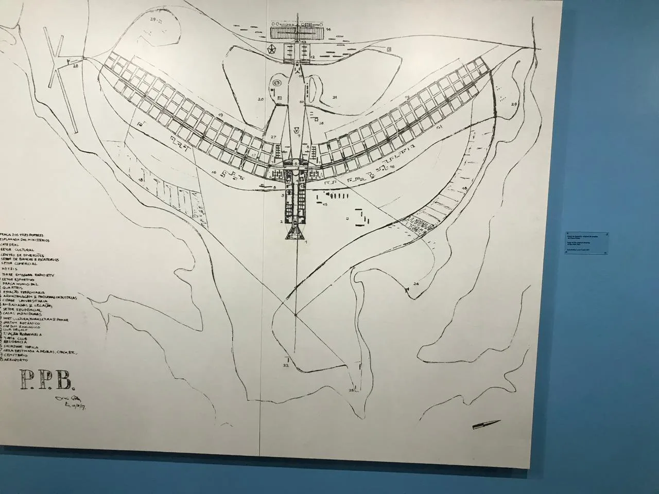 Lúcio Costa's cross/airplane-shaped pilot-plan sketch for Brasília (1957), displayed at the Espaço Lúcio Costa, Praça dos Três Poderes. The drawing shows the famous bird/airplane geometry of the Plano