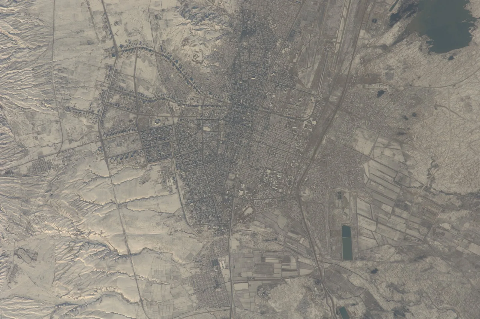Astronaut photograph of Ashgabat from the ISS, showing the rectilinear grid rebuilt after the 1948 earthquake and the 1949 reconstruction plan.